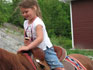 Une petite fille montant en selle western