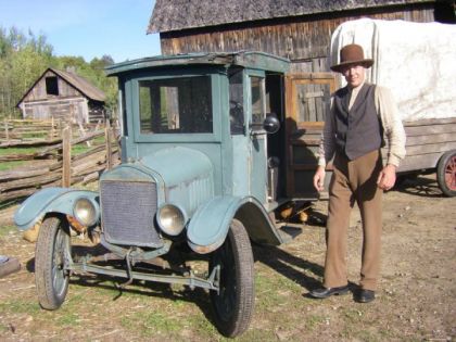 Voiture antique devant une grange
