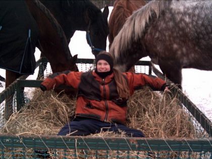 Assis dans le foin avec les chevaux